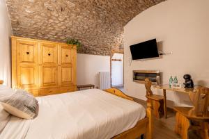 a bedroom with a bed and a table and a tv at Antica corte in Zogno