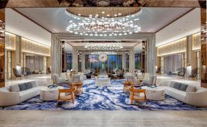 a lobby with couches and tables and a chandelier at Waldorf Astoria Riviera Maya in Cancún