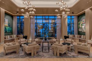 a waiting room with chairs and tables and a large window at Waldorf Astoria Riviera Maya in Cancún +136 photos