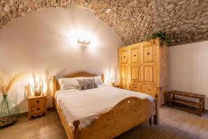 a bedroom with a bed and a wooden cabinet at Antica corte in Zogno +22 photos