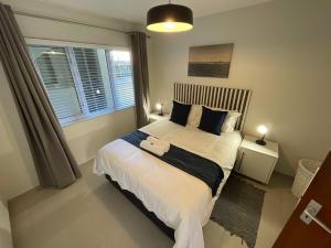 a bedroom with a large bed and a window at Central Apartment at Bismarck5 in Swakopmund