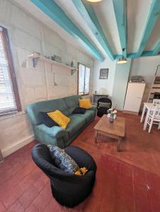 a living room with a green couch and chairs at La rose d'Alfred in Chédigny
