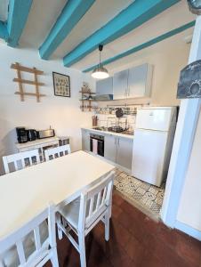 a kitchen with a white table and a refrigerator at La rose d'Alfred in Chédigny +15 photos