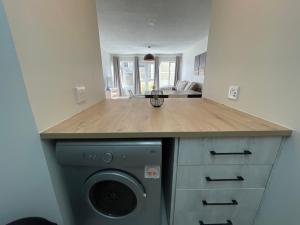 a kitchen with a washing machine under a counter at Central Apartment at Bismarck5 in Swakopmund +9 photos