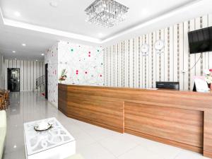 a lobby with a reception desk and a tv at RedDoorz @ Baloi Batam in Batam Center +17 photos