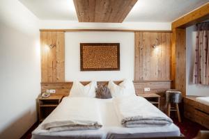 a bedroom with a white bed with wooden walls at Pension Singer in Innsbruck +62 photos