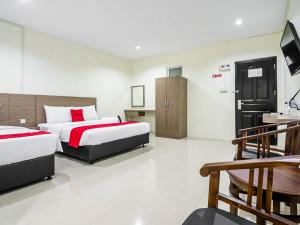 a hotel room with two beds and a television at RedDoorz @ Baloi Batam in Batam Center