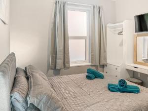 a bedroom with a bed with two slippers on it at Rose - Uk49363 in Bridlington