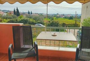 a table and chairs on a balcony with a view at Στης Χαράς in Porto Heli