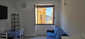 a living room with a blue couch and a window at La Casetta Mare in Palinuro