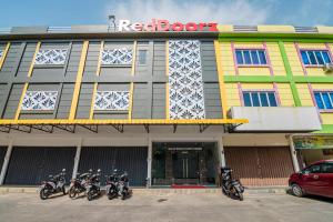 a row of motorcycles parked in front of a building at RedDoorz @ Baloi Batam in Batam Center