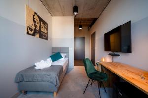 a bedroom with a bed and a desk with a television at ON Rooms Łódź in Łódź +41 photos