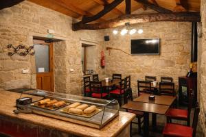 a restaurant with a counter with bread on it at Miraz Albergue O Abrigo in Miraz
