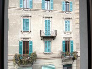 a building with blue shutters and a balcony at Menaggio Lake Como Elegance in Menaggio +36 photos