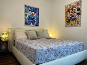 a bedroom with a bed with two pictures on the wall at Menaggio Lake Como Elegance in Menaggio