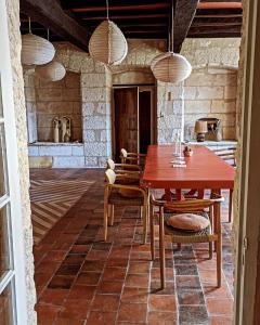 a dining room with a wooden table and chairs at Maison Nathis in Saint-Sulpice-de-Roumagnac