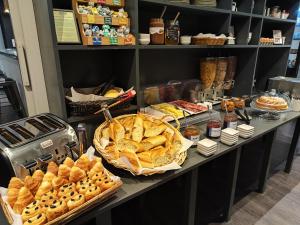 a buffet with bread and pastries on a table at Hôtel des Alpes in Annecy
