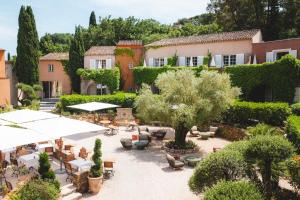 a courtyard with tables and chairs and a building at Hotel La Mandarine Saint Tropez in Saint-Tropez