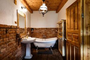 a bathroom with a sink and a bath tub and a sink at 100éves Vendégház in Hárskút +4 photos