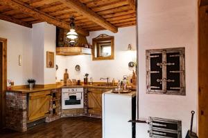 a kitchen with wooden cabinets and a white refrigerator at 100éves Vendégház in Hárskút