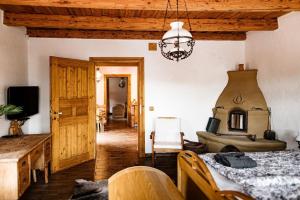 a room with a bed and a couch and a chandelier at 100éves Vendégház in Hárskút