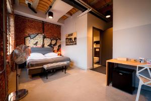 a bedroom with a bed and a brick wall at ON Rooms Łódź in Łódź