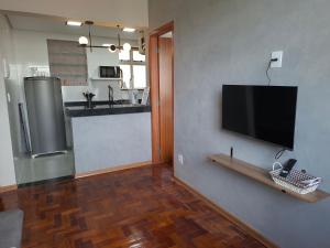 a living room with a flat screen tv on a wall at Centro de BH, Ar-Condicionado, Wi-Fi Rápido, 6min Rodoviária, Portaria 24h in Belo Horizonte +9 photos