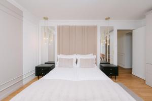 a white bedroom with a large white bed with two night stands at The Loft in Sovata +57 photos
