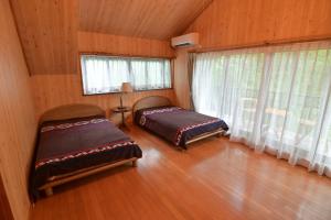 a bedroom with two beds in a wooden room at ve-nasu本館 in Nasu