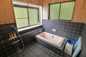 a bathroom with a bath tub and a sink at ve-nasu本館 in Nasu +20 photos