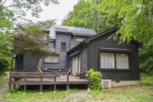 a black house with a porch and a bench at ve-nasu本館 in Nasu