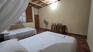 a room with two beds and a fan in it at Centro Ecoturistico Ya´ajche in Lacanjá