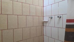 a bathroom with white tiled walls and white fixtures at Centro Ecoturistico Ya´ajche in Lacanjá