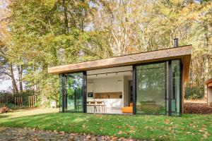 a modern house with glass walls and trees at Glass Forest Cabin Holenduif I Privacy I 3BR Quiet in Oostkamp