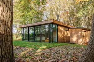 a house in the woods with glass walls at Glass Forest Cabin Holenduif I Privacy I 3BR Quiet in Oostkamp
