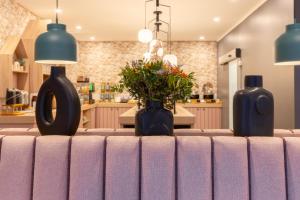 a table with two blue vases and flowers on it at Hotel Boulevard in Stuttgart