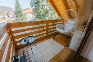 a balcony with a rattan chair and a table at The Loft in Sovata