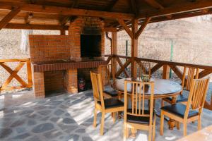 a patio with a table and chairs and a fireplace at The Loft in Sovata
