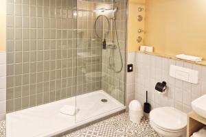 a bathroom with a shower with a toilet and a sink at Hotel Boulevard in Stuttgart