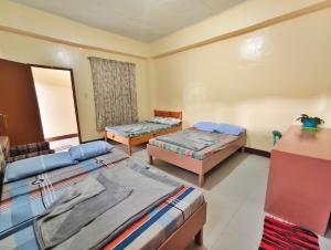 a room with three beds and a window at Best Sagada Lodge within City Proper! in Sagada