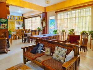 a living room with a bench and tables and chairs at Best Sagada Lodge within City Proper! in Sagada