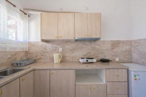 a kitchen with wooden cabinets and a counter top at Ionian Breeze Apartments in Kavos +21 photos