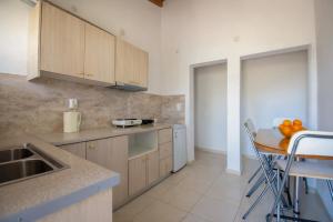 a kitchen with wooden cabinets and a table with oranges on it at Ionian Breeze Apartments in Kavos