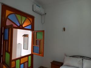a room with a stained glass window next to a couch at dar rachid in Fez +6 photos