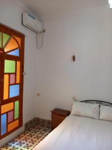 a bedroom with a bed and a stained glass window at dar rachid in Fez