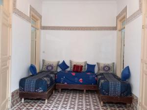 a room with two beds with blue pillows at dar rachid in Fez