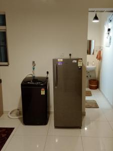 a refrigerator and a trash can in a room at MaEra's Den in Hinjewadi