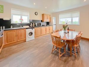 a kitchen with a wooden table and a dining room at Uk47550 - Cairnsmore Cottage in Newton Stewart