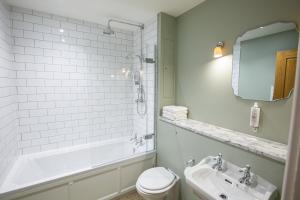 a bathroom with a tub and a toilet and a sink at The Grange in Upper Arley