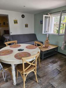 a living room with a table and chairs and a couch at 1262 Chemin des Pignatelles in La Motte